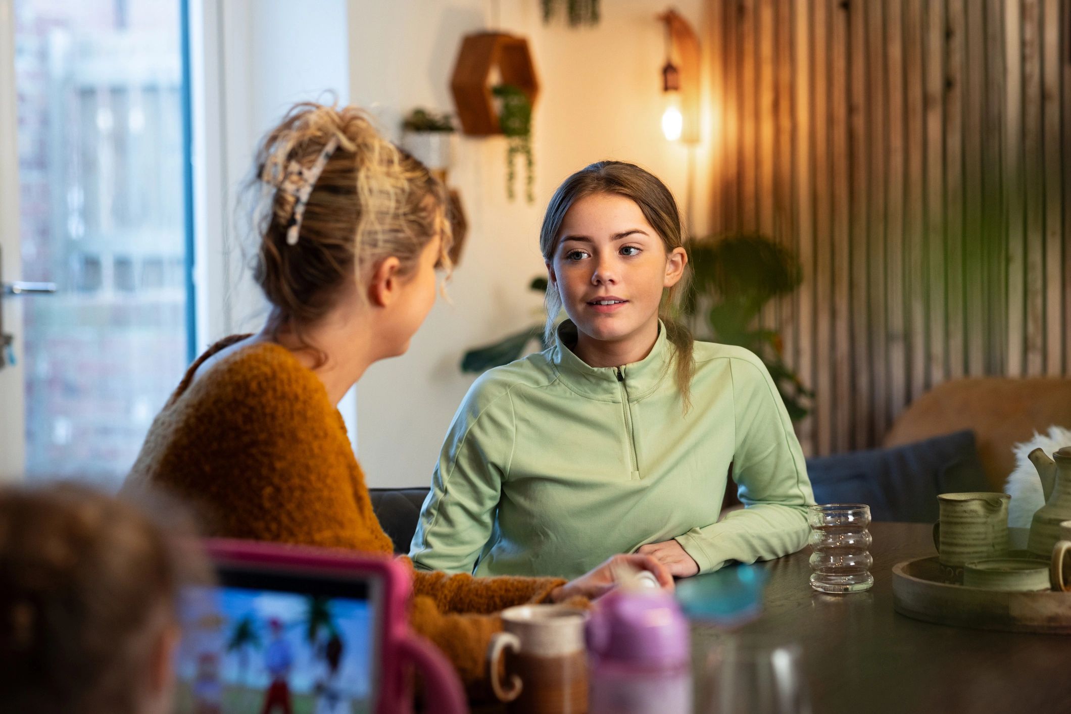 Older parent and adult daughter talking at home