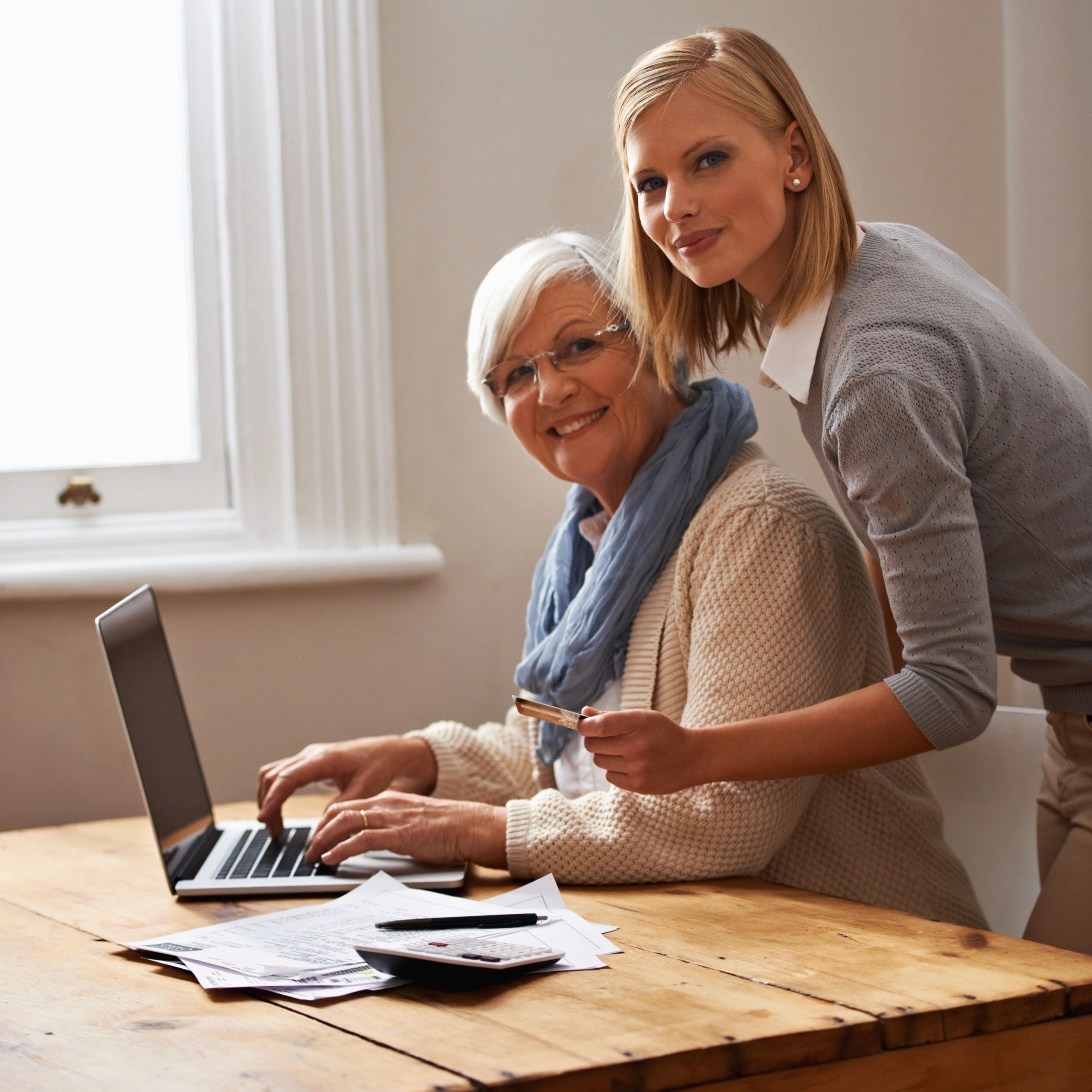 Adult daughter helping an older parent review paperwork at home